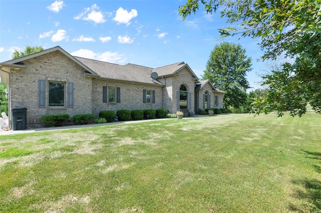 view of front of house with a front yard and brick siding