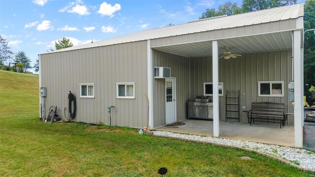 back of property featuring ceiling fan, a wall mounted air conditioner, a patio area, and a lawn