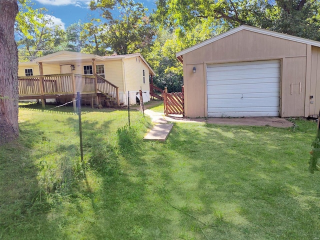 exterior space featuring an outbuilding, a detached garage, fence, driveway, and a wooden deck