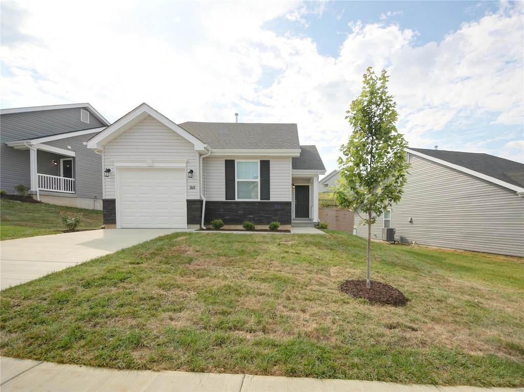 view of front of property with a front yard, cooling unit, and a garage