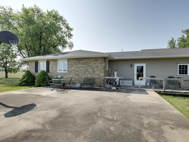 back of house featuring a wooden deck and a patio