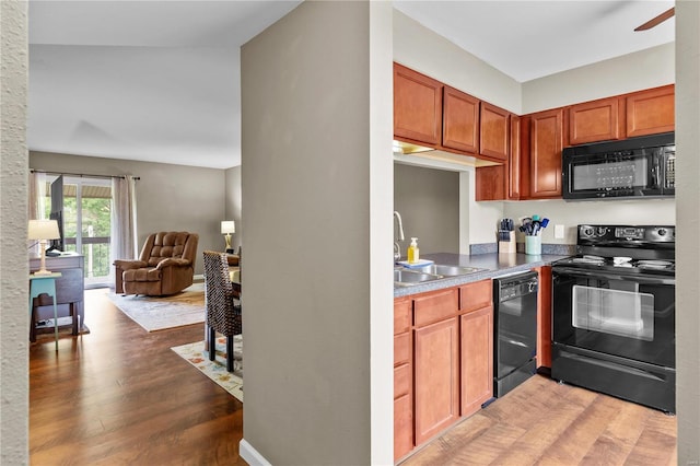 kitchen featuring sink, lofted ceiling, black appliances, dark hardwood / wood-style floors, and ceiling fan