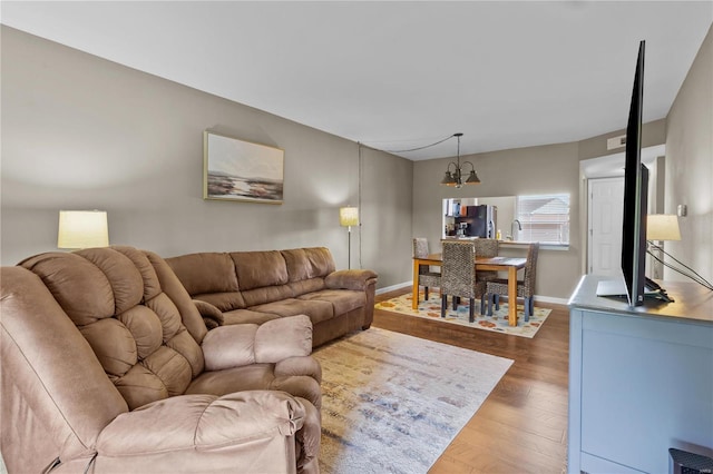 living room with hardwood / wood-style flooring and a notable chandelier