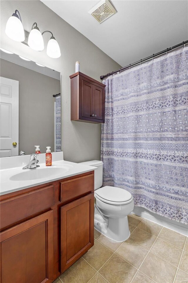 bathroom with tile patterned flooring, vanity, toilet, and curtained shower