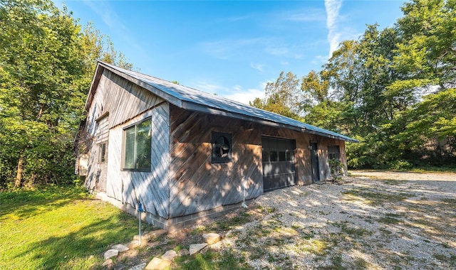 view of side of home with an outbuilding and a lawn