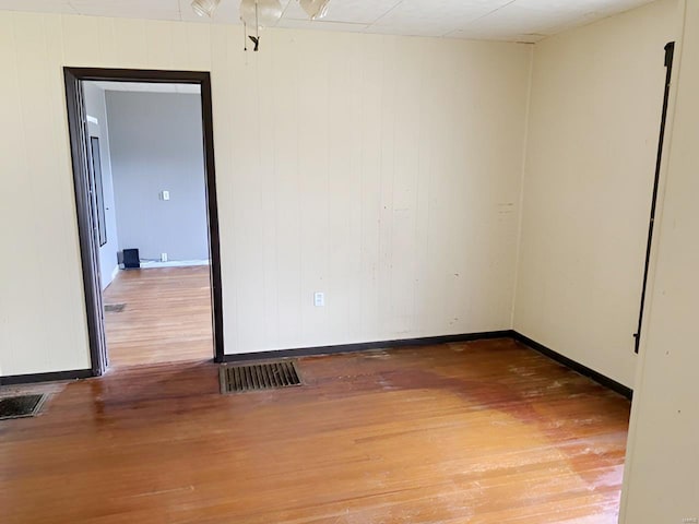 unfurnished room with visible vents, baseboards, and wood finished floors