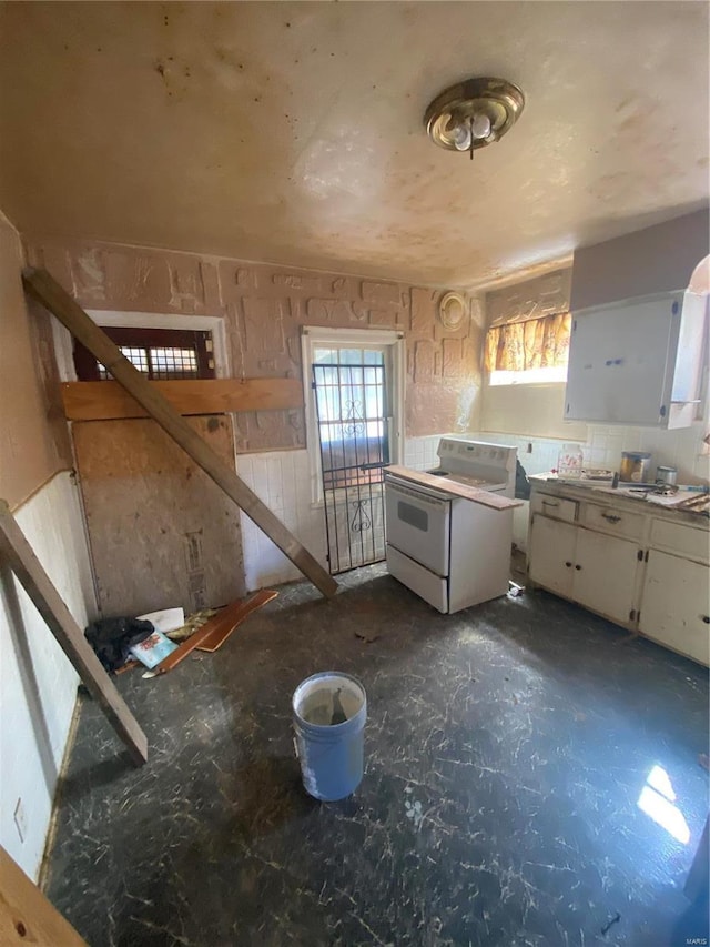 kitchen featuring white cabinetry and electric range