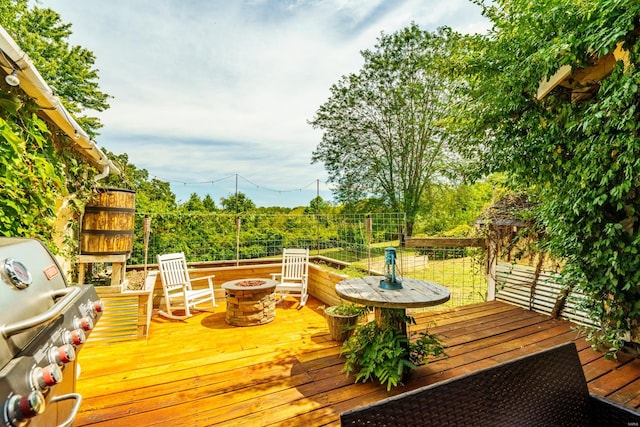 wooden deck with a grill and an outdoor fire pit