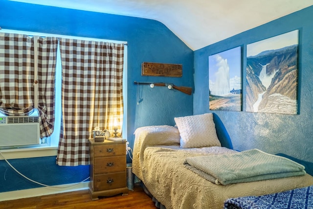 bedroom featuring cooling unit, hardwood / wood-style floors, and vaulted ceiling