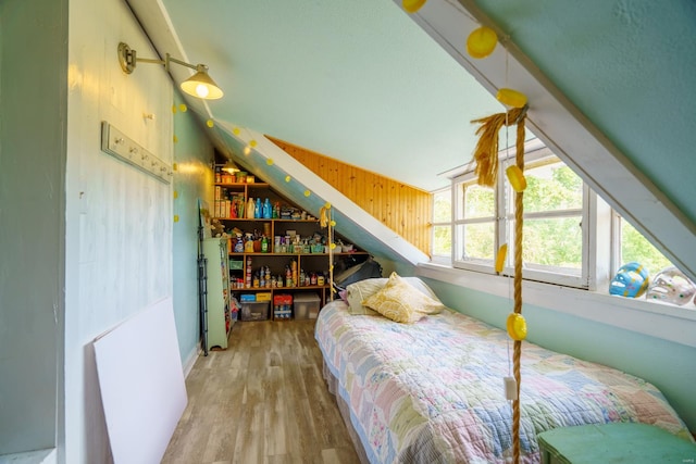 bedroom with vaulted ceiling and hardwood / wood-style flooring