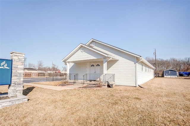 rear view of property featuring a porch and a lawn