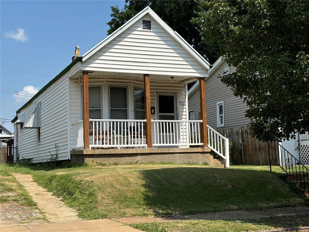 bungalow-style house with a front lawn and covered porch