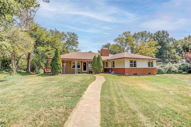 ranch-style home featuring brick siding, a chimney, and a front lawn