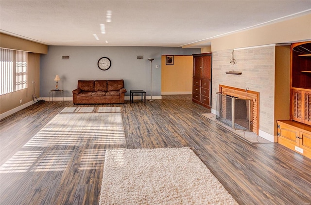 unfurnished living room featuring baseboards, a tiled fireplace, and wood finished floors