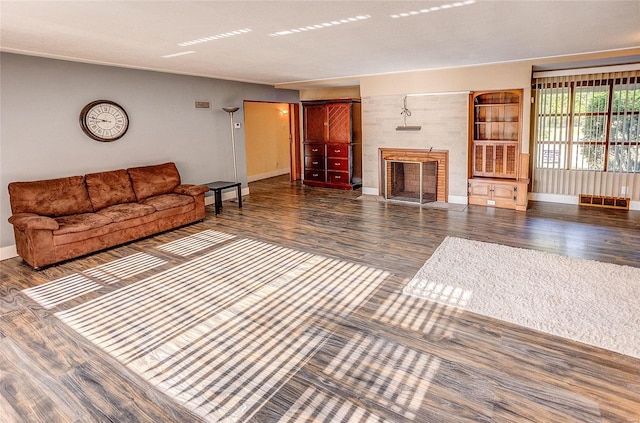 unfurnished living room with a fireplace, baseboards, and wood finished floors