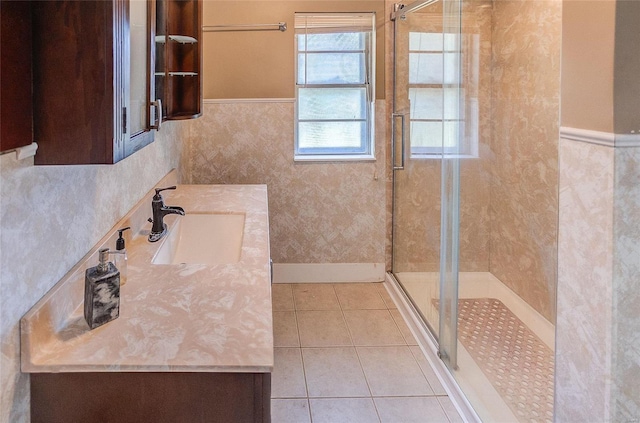 full bath featuring a stall shower, a wainscoted wall, tile patterned flooring, and vanity