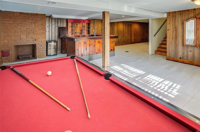 recreation room featuring wood walls and a fireplace