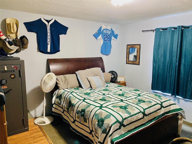 bedroom featuring a textured ceiling and hardwood / wood-style flooring