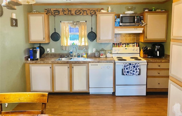 kitchen with tasteful backsplash, sink, light wood-type flooring, and white appliances