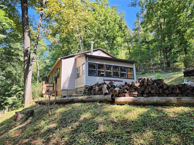 view of front of home with fence and a wooded view