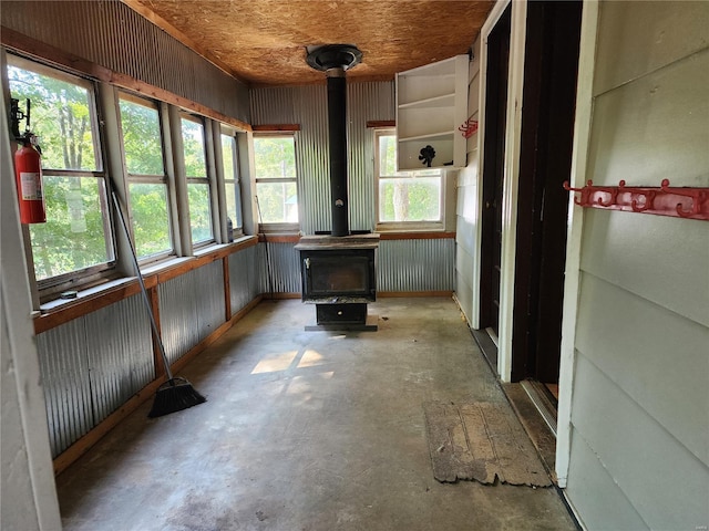 unfurnished sunroom featuring a wood stove