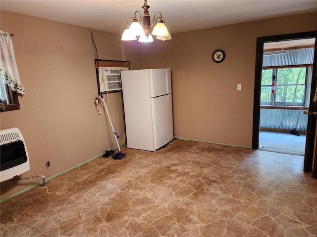 interior space with a wall unit AC, freestanding refrigerator, heating unit, stone floors, and a notable chandelier