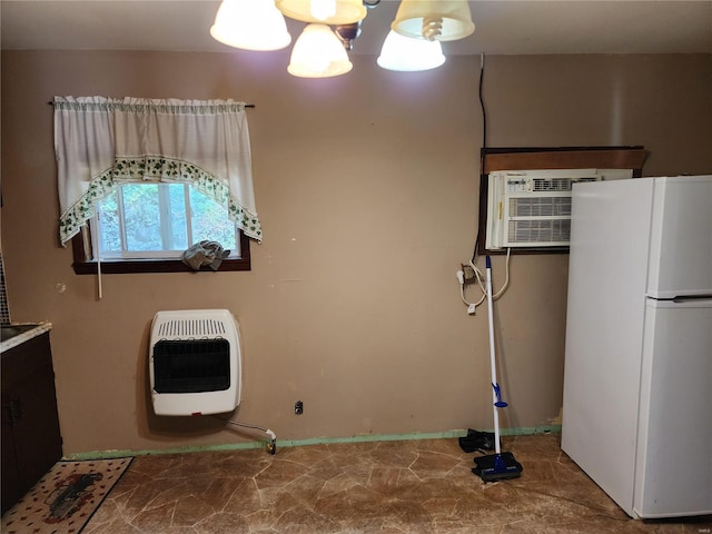 laundry area featuring a wall mounted AC, an inviting chandelier, and heating unit