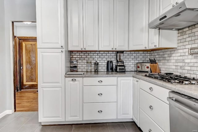 kitchen featuring white cabinets, backsplash, appliances with stainless steel finishes, and light tile patterned flooring