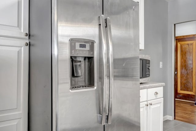 interior space featuring white cabinetry, stainless steel refrigerator with ice dispenser, and light hardwood / wood-style flooring