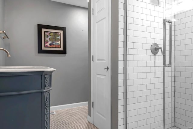 bathroom featuring tiled shower, tile patterned floors, and vanity