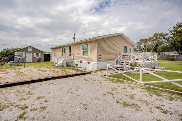 rear view of house featuring an outdoor structure and a yard