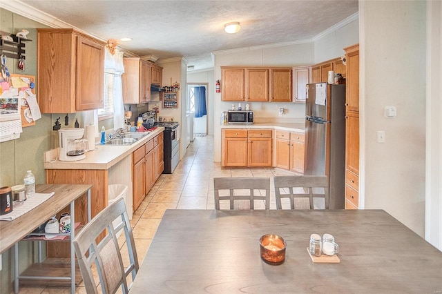 kitchen with light tile patterned flooring, sink, ornamental molding, a textured ceiling, and stainless steel appliances