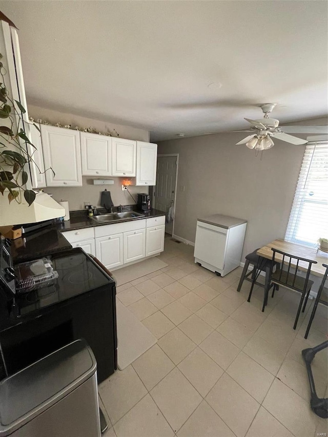 kitchen featuring ceiling fan, sink, white cabinetry, and light tile patterned floors