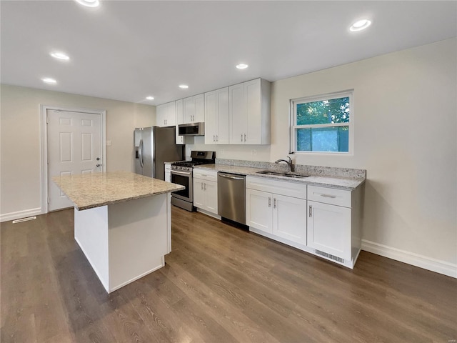 kitchen featuring dark hardwood / wood-style flooring, white cabinetry, sink, a center island, and stainless steel appliances