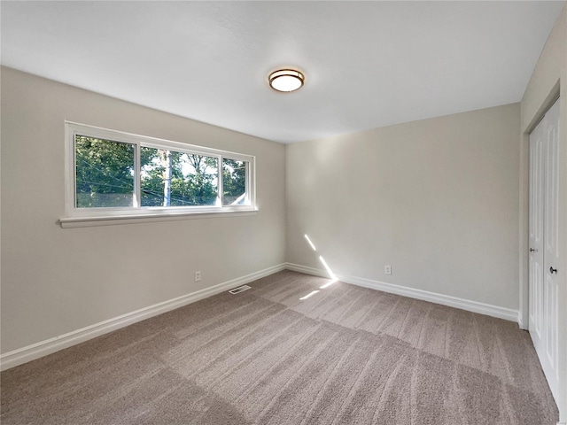 unfurnished bedroom featuring a closet and light colored carpet