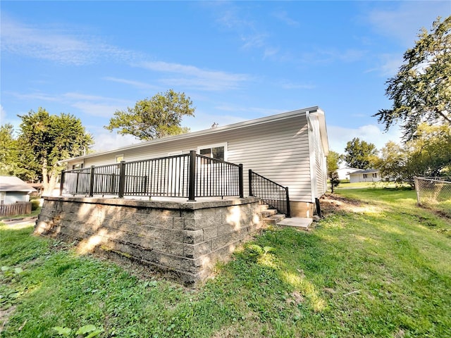 back of property featuring a deck and a lawn