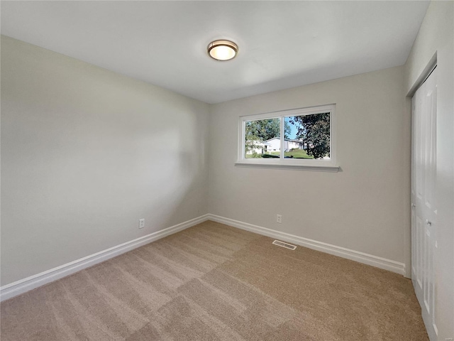 unfurnished bedroom with a closet and light carpet