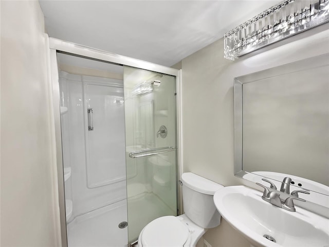 bathroom with sink, toilet, and a shower with shower door