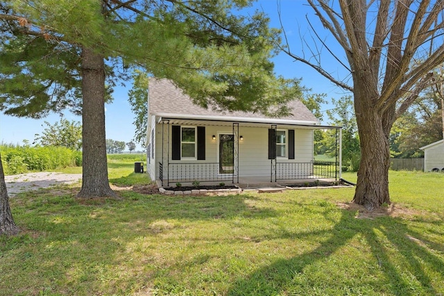 bungalow with roof with shingles, a porch, and a front lawn