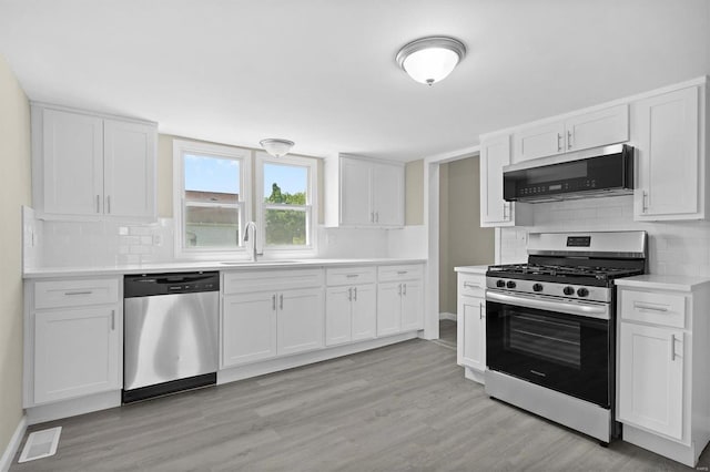 kitchen featuring visible vents, white cabinets, light wood-style flooring, appliances with stainless steel finishes, and light countertops