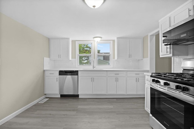 kitchen featuring a sink, white cabinetry, light countertops, appliances with stainless steel finishes, and backsplash