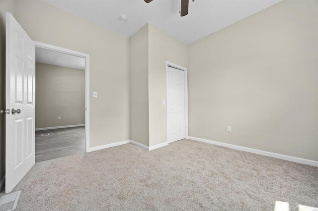 unfurnished bedroom featuring baseboards, visible vents, a closet, and light colored carpet