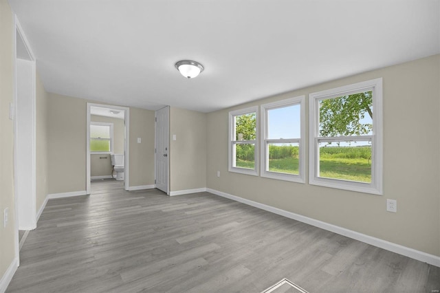 spare room with light wood-style flooring and baseboards