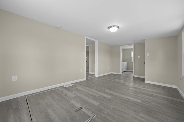 empty room with visible vents, baseboards, and wood finished floors