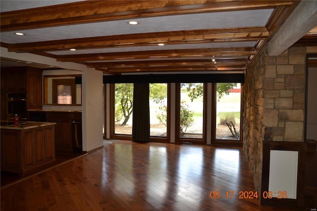 doorway to outside with beamed ceiling, dark hardwood / wood-style floors, and plenty of natural light