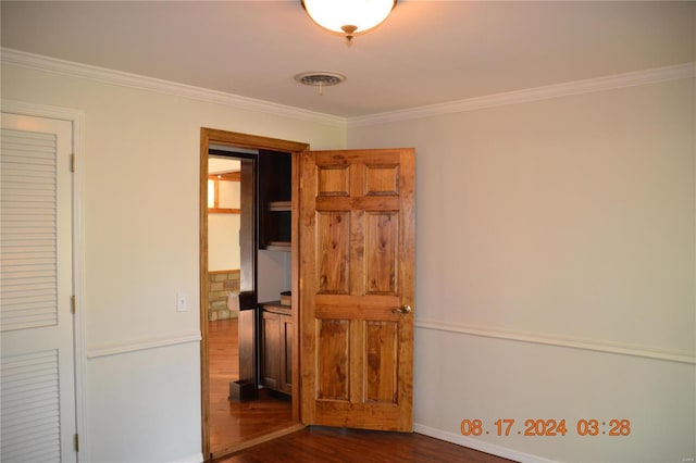 unfurnished bedroom with crown molding and dark hardwood / wood-style flooring