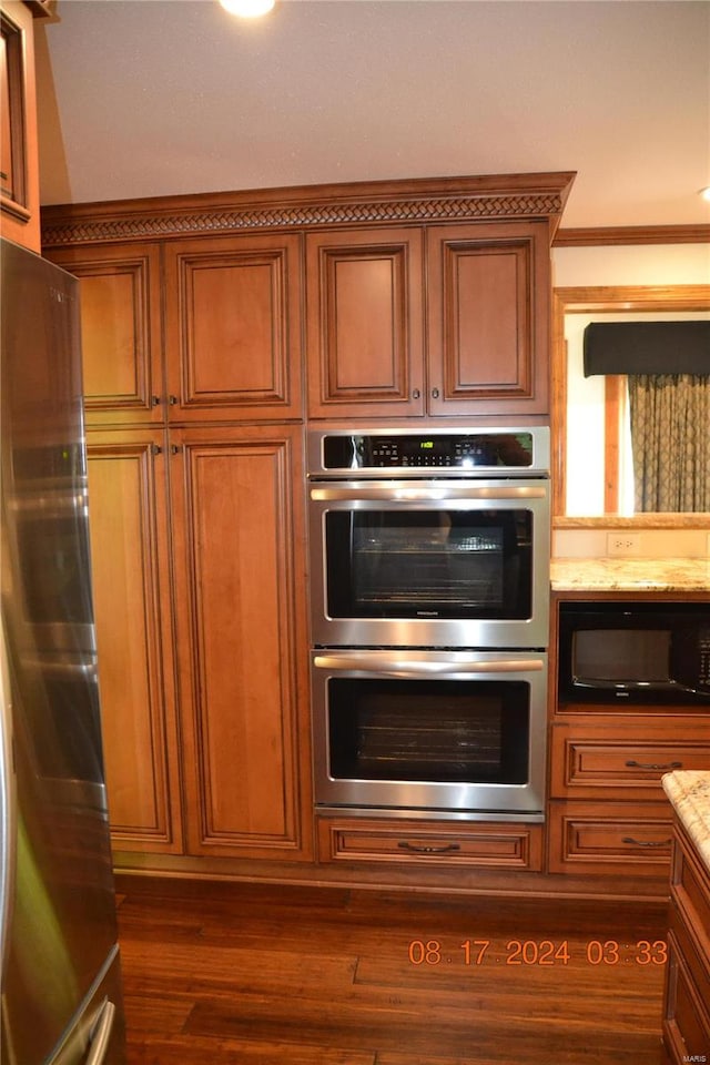 kitchen with dark hardwood / wood-style floors, stainless steel appliances, and ornamental molding