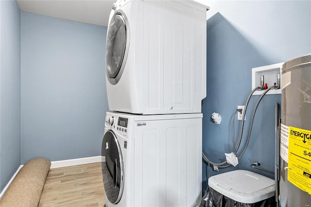 laundry room with electric water heater, light hardwood / wood-style floors, and stacked washer / dryer