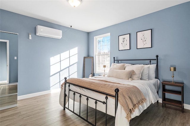 bedroom featuring a wall mounted air conditioner and hardwood / wood-style floors