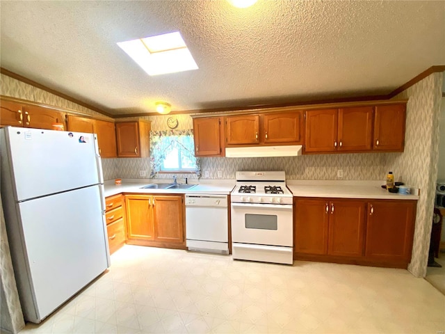 kitchen featuring white appliances, light countertops, a sink, and under cabinet range hood